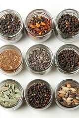 Aesthetic Display of Various Spices in Glass Jars on White Surface