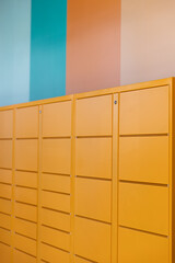 Orange Lockers with vertical pastel stripes on wall - blue pink