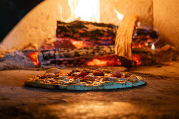 Flatbread cooking in pizza oven with flames