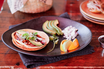 Taco on plate with tortillas and garnish