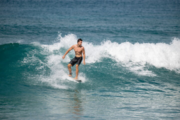 Male surfer rides wave in Oahu Hawaii