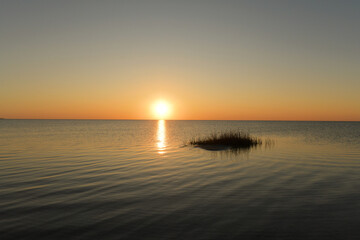 Seagrass island in calm waters colorful sunset Cape Hatteras Nat