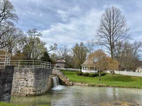 Stone canal lock and waterfall beside gazebo in peaceful town park