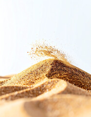 Golden grains form a textured landscape, with particles scattering gently, creating a dynamic visual of movement and depth