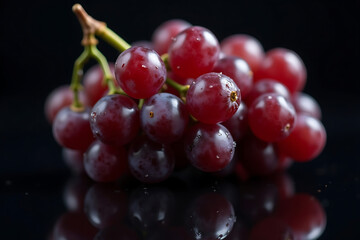 Fototapeta premium Close-up of fresh red grapes with water droplets and reflection on a black surface