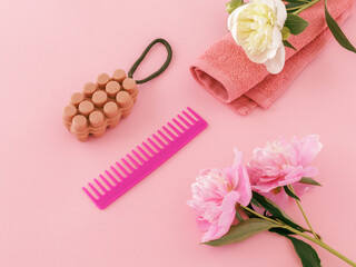 Towel with a soap and a comb on the pink background.
