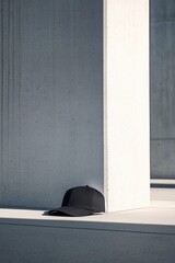 Black Cap Leaning Against Concrete Wall in Modern Urban Setting