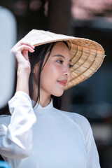 Vietnamese girl wearing a hat and Vietnamese dress.