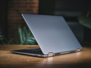 A sleek silver laptop is elegantly positioned on a wooden surface, showcasing its modern design.