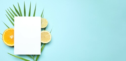 Summer tropical composition with a white card. Green palm leaf and tropical fruits on a blue background. Summer concept. Flat lay, top view, copy space