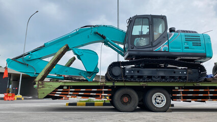 Heavy new excavator on transportation truck