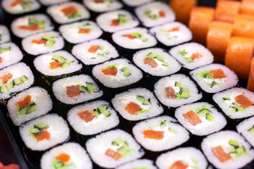 A delightful bunch of sushi rolls are neatly lined up on a table
