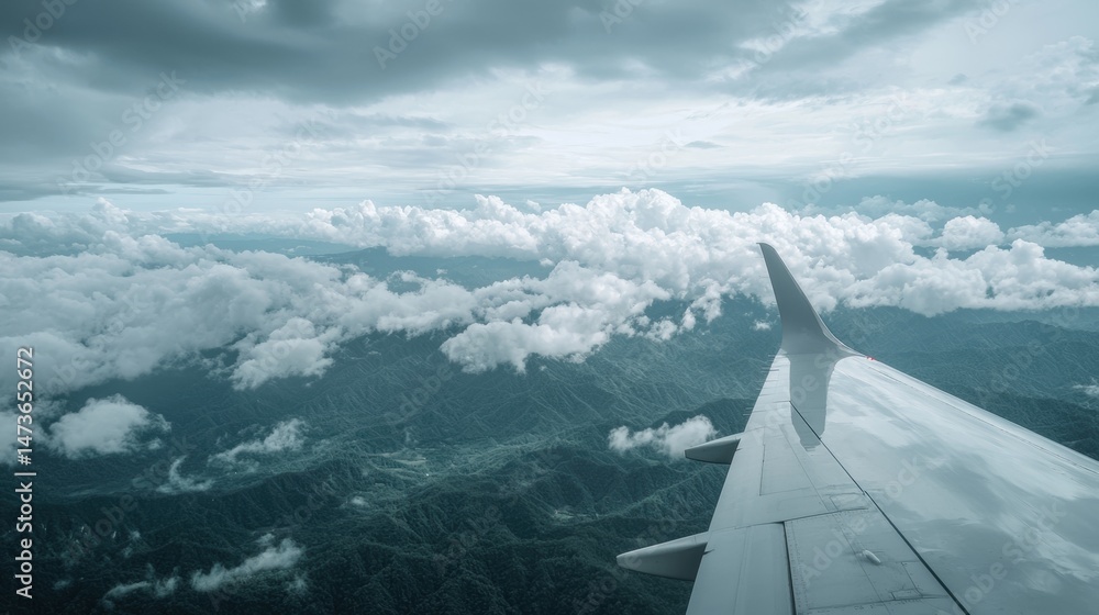 Poster a view from an airplane window, with a mountain range and clouds below.