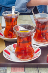 Traditional Turkish tea in tulip glasses served with spoons on white saucers