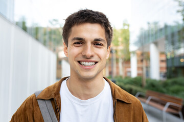Happy young man smiling outdoors in urban environment