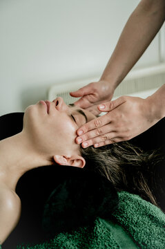 Young woman massagist making face massage