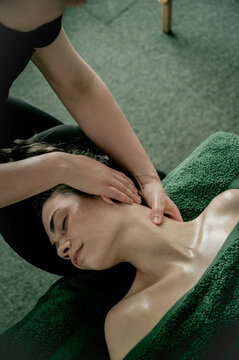 Young woman massagist making neck massage  to client