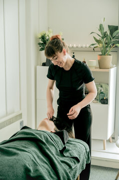 Young woman massagist making massage to her client