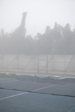 Thick dense grey fog at tennis and handball courts park
