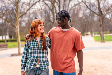 Obraz premium Happy multiracial couple walking together in park