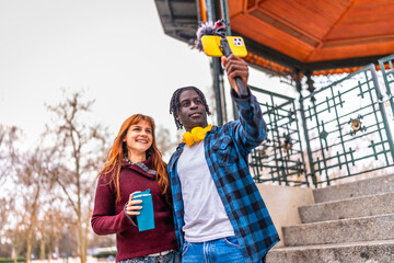 Content creators filming urban video blog with smartphone gimbal and microphone