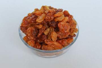 Pile of raisin in a transparent bowl, isolated on white background