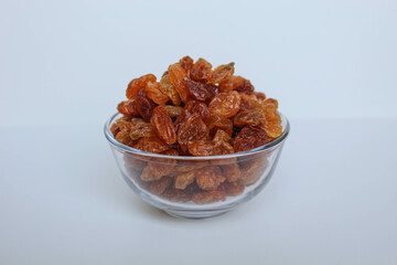 Pile of raisin in a transparent bowl, isolated on white background