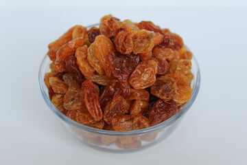 Pile of raisin in a transparent bowl, isolated on white background