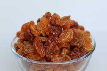 Pile of raisin in a transparent bowl, isolated on white background