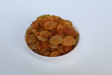 Raisins in a small white bowl, isolated on white background