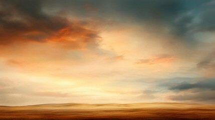 Obraz premium Landscape photograph of a vast open field with a cloudy sky in the background. the sky is filled with orange and yellow hues, with the sun setting in the distance.
