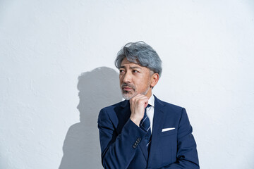 考えるミドルのスーツを着た男性