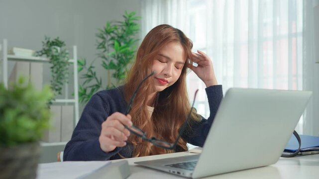 Asian young businesswoman typing on laptop and overworking from home. 