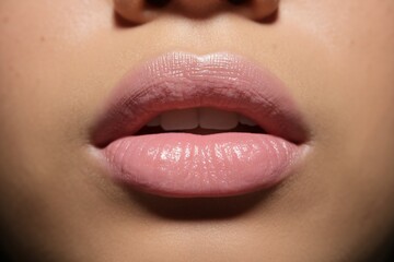 Fototapeta premium Close-up of smooth, hydrated lips with a soft pink tint, showcasing a glossy finish and natural beauty.
