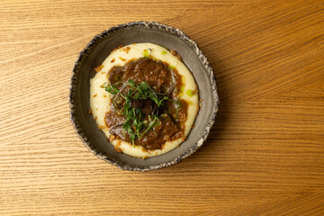 Top view of Wagyu beef cheeks with a creamy truffle sauce and mashed potato