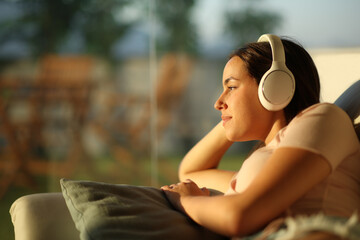Woman relaxing listening music with headphone at home