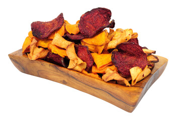 Hand cooked root vegetable crisps made from beetroot, sweet potato and parsnip in an olive wood bowl isolated on a white background
