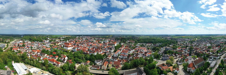 Fototapeta premium Eine beeindruckende Luftaufnahme von Günzburg, einer charmanten Stadt in Bayern. Die Stadt ist geprägt von einer harmonischen Mischung aus historischen und modernen Gebäuden mit roten Ziegeldächern.