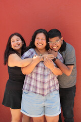 Two Latina sisters and a dark-skinned brother spend quality time together as friends and freelance coworkers