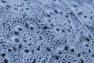 Close up of hands of unrecognizable woman knitting handmade clothes with spokes using  wool yarn....