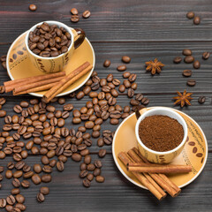 Ground coffee and roasted coffee beans in cups. Cinnamon sticks on saucer. Coffee beans and star anise on table.