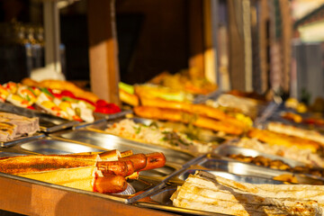 Hot dog with sausage in a box on a counter in a street market.
