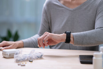 Obraz premium Senior Asian Woman taking blood pressure test on smartwatches.