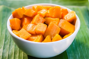 a bowl of cut mangoes on a banana leaf background.tropical fruit.