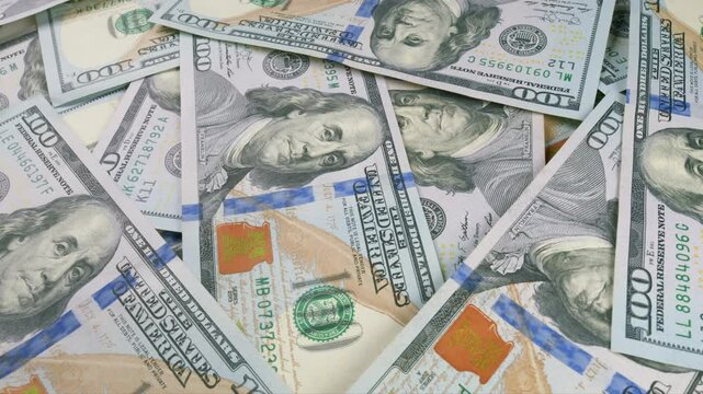 A visually appealing background of stacked hundred dollar bills symbolizes wealth and prosperity