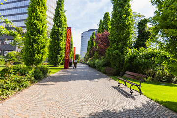 View along a curved paved pathway in the contemporary gardens urban park in Timisoara, Romania....