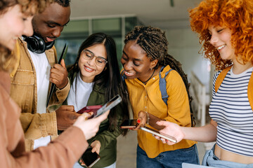 Group of cheerful university students collaborating on assignments while enjoying their time...