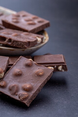 Chocolate cupcake with icing and chocolate bar in Dark lighting,Homemade delicious chocolate muffin on wooden background close-up