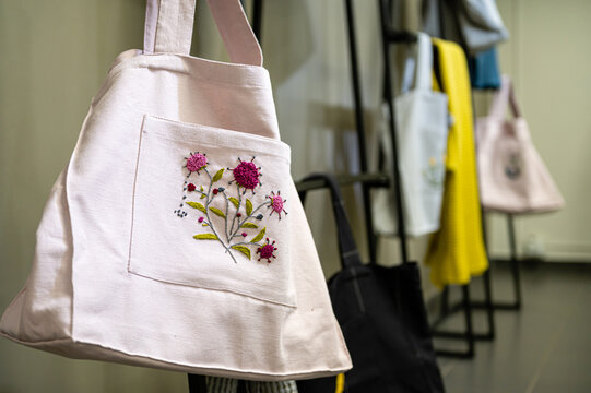Unique embroidered bags displayed in a workshop environment for craft enthusiasts