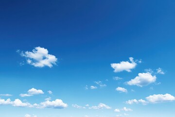 A vast expanse of cerulean blue sky dotted with fluffy white cumulus clouds